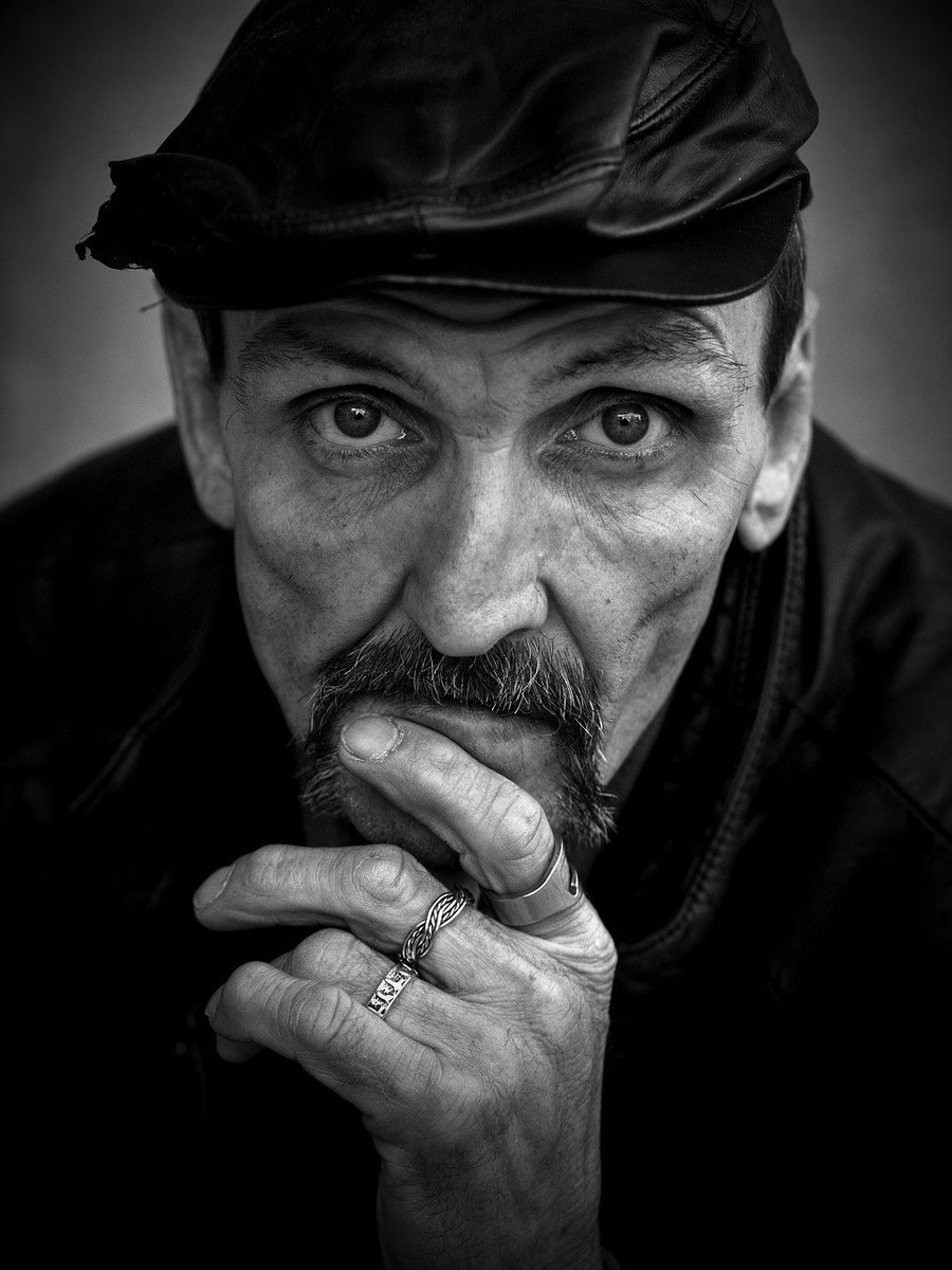 Moody black and white character portrait of a man in a leather cap