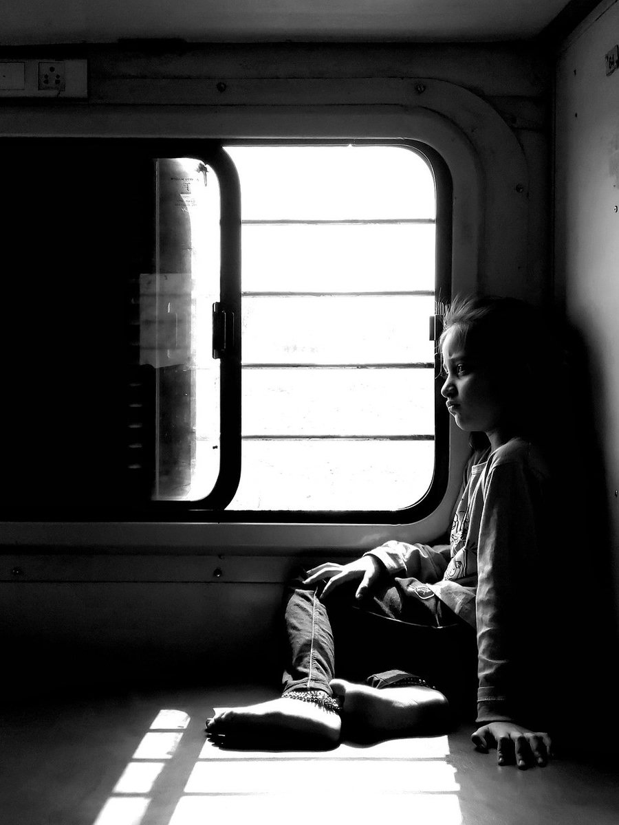 Figure framed by hard geometric window light and shadow